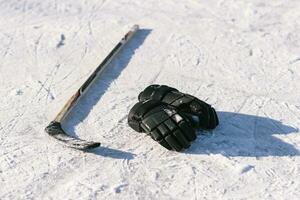 de handskar och hockey pinne lägga på de snö foto