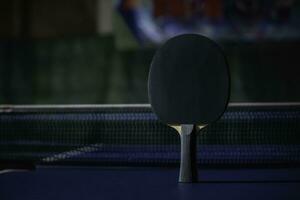 tabell tennis racket på de blå ping pong tabell foto
