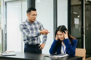rasande två asiatisk affärsmän argumenterar starkt efter framställning en misstag på arbete i kontor foto