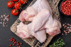 färsk rå kyckling vingar med salt och kryddor beredd för bakning foto
