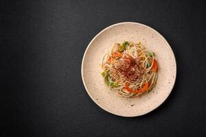 gott maträtt av asiatisk kök med ris spaghetti, kyckling, sparris, peppar, sesam frön foto