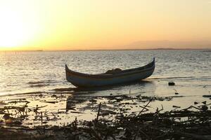 båt i de sjö på solnedgång. rodd båt flytande över de limboto sjö vattnen. gorontalo, indonesien foto