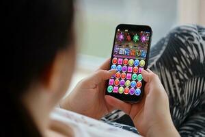 pussel och drakar mobil ios spel på iphone 15 smartphone skärm i kvinna händer under mobil gameplay foto
