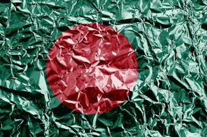 bangladesh flagga avbildad i måla färger på skinande skrynkliga aluminium folie närbild. texturerad baner på grov bakgrund foto