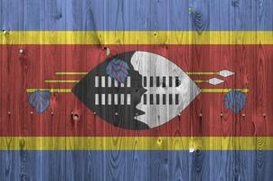 swaziland flagga avbildad i ljus måla färger på gammal trä- vägg. texturerad baner på grov bakgrund foto