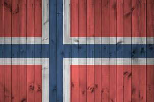 Norge flagga avbildad i ljus måla färger på gammal trä- vägg. texturerad baner på grov bakgrund foto