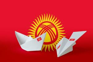 kyrgyzstan flagga avbildad på papper origami flygplan och båt. handgjort konst begrepp foto