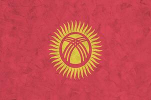 kyrgyzstan flagga avbildad i ljus måla färger på gammal lättnad putsning vägg. texturerad baner på grov bakgrund foto