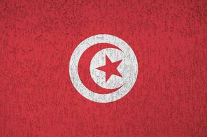 tunisien flagga avbildad i ljus måla färger på gammal lättnad putsning vägg. texturerad baner på grov bakgrund foto