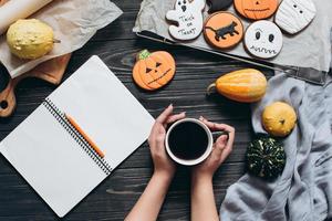 flicka som håller kopp kaffe, pepparkakor för halloween foto