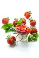 ljuv hemlagad yoghurt med jordgubb sylt och färsk jordgubbar i en glas kopp foto