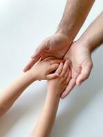 vuxen och barn håll deras händer tillsammans. fäder dag barn ger hand till vuxen foto