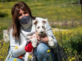 kvinna med vit schnauzer hund i gula blommor fält foto