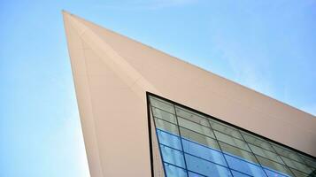 glas byggnad med transparent Fasad av de byggnad och blå himmel. strukturell glas vägg reflekterande blå himmel. abstrakt modern arkitektur fragment. samtida arkitektonisk bakgrund. foto