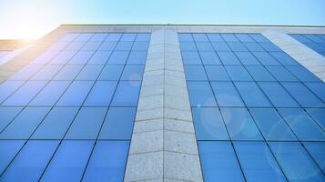 glas byggnad med transparent Fasad av de byggnad och blå himmel. strukturell glas vägg reflekterande blå himmel. abstrakt modern arkitektur fragment. samtida arkitektonisk bakgrund. foto