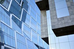 glas byggnad med transparent Fasad av de byggnad och blå himmel. strukturell glas vägg reflekterande blå himmel. abstrakt modern arkitektur fragment. samtida arkitektonisk bakgrund. foto