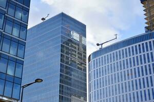 glas byggnad med transparent Fasad av de byggnad och blå himmel. strukturell glas vägg reflekterande blå himmel. abstrakt modern arkitektur fragment. samtida arkitektonisk bakgrund. foto