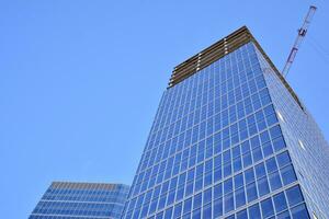 glas byggnad med transparent Fasad av de byggnad och blå himmel. strukturell glas vägg reflekterande blå himmel. abstrakt modern arkitektur fragment. samtida arkitektonisk bakgrund. foto