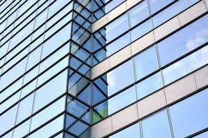 glas byggnad med transparent Fasad av de byggnad och blå himmel. strukturell glas vägg reflekterande blå himmel. abstrakt modern arkitektur fragment. samtida arkitektonisk bakgrund. foto