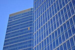 glas byggnad med transparent Fasad av de byggnad och blå himmel. strukturell glas vägg reflekterande blå himmel. abstrakt modern arkitektur fragment. samtida arkitektonisk bakgrund. foto