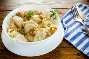 ukrainska vareniky eller pierogi fylld med potatis och svamp, eras med friterad lök. foto
