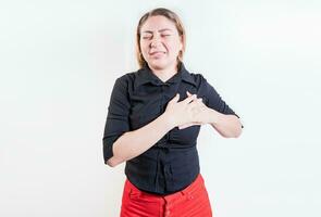 latin kvinna med hjärta smärta på isolerat bakgrund. ung kvinna med takykardi. begrepp av människor med hjärta problem foto