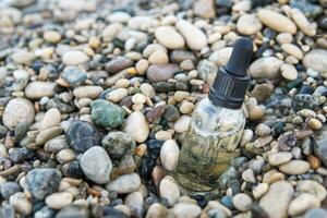 kosmetisk serum i en glas flaska med en pipett på stenar foto