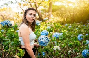 kvinna i en hortensia fält. skön flicka i en naturlig blomma barnkammare. porträtt av ung kvinna i en hortensia fält. el crucero - managua, nicaragua foto