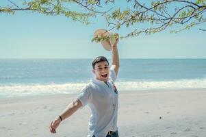 Lycklig stilig man på semester utomhus, Lycklig latin ung man på de strand, turist resa begrepp foto