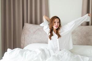 porträtt vacker kvinna vaknar på sängen foto