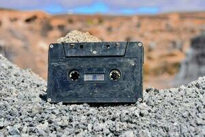 ett gammal kassett Sammanträde på topp av några stenar foto