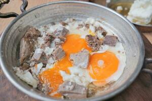turkiska krypterade ägg med rostad kött i koppar panorera foto