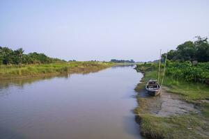 kanal med grön gräs och vegetation reflekterad i de vatten nära padma flod i bangladesh foto