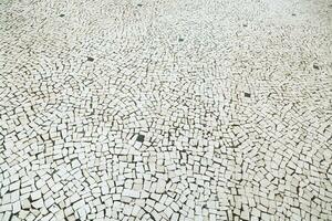 gammal gata väg asfalterad yta sten trottoar gångväg textur. granit gatsten trottoar bakgrund. abstrakt bakgrund av gammal kullersten trottoar årgång stil Europa. foto