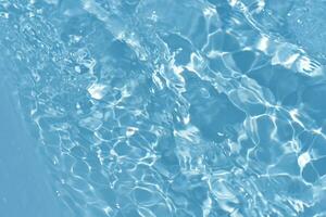 defokusering suddig transparent blå färgad klar lugna vatten yta textur med stänk reflexion. trendig abstrakt natur bakgrund. vatten vågor i solljus med kopia Plats. blå vattenfärg glans. foto