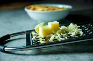 riven parmesanost, rivjärn med cheddar foto