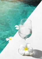 glas vatten förfriskning dryck på en pool sida foto