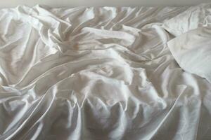 topp se av rynkor på ett obäddad säng ark foto