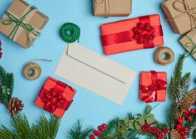 jul dekor, gåvor insvept i röd papper och en brev på en blå bakgrund, topp se foto