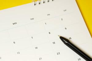 kalender månad schema till göra utnämning möte eller klara av tidtabell varje dag lägga och penna på gul bakgrund för planera arbete och resa begrepp. foto