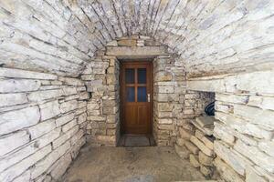 bild av en brun ingång dörr till en bostads- byggnad med ett antik Fasad foto