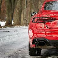 modern röd sport bil i de vinter- skog bakgrund, bil tapet foto