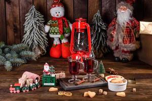 jul glöggrött vin med kryddor och frukter på ett mörkt bord. foto