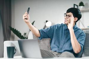 asiatisk man som använder smartphone för videokonferenssamtal online. foto