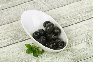svarta oliver i skålen foto