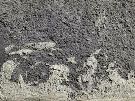 grungy vägg av grå betong textur med knäckt yta från sand och cement material. foto