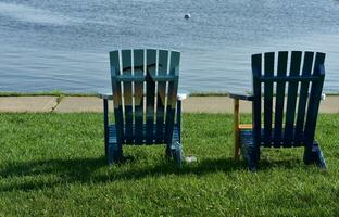 par av målad adirondack stolar i plymouth hamn foto