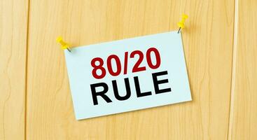 80 och 20 regel tecken skriven på klibbig notera fästs på trä- vägg foto