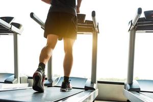 ben av idrottsman kör på löpband i fitness gym foto