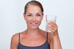 kvinna innehav glas av vatten på vit bakgrund foto